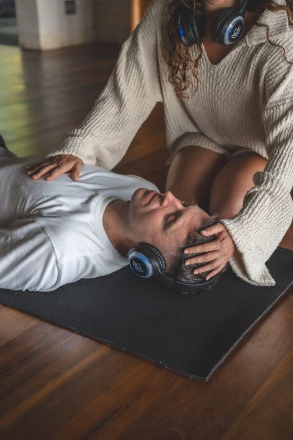 Man laying on mat, woman touching his head.