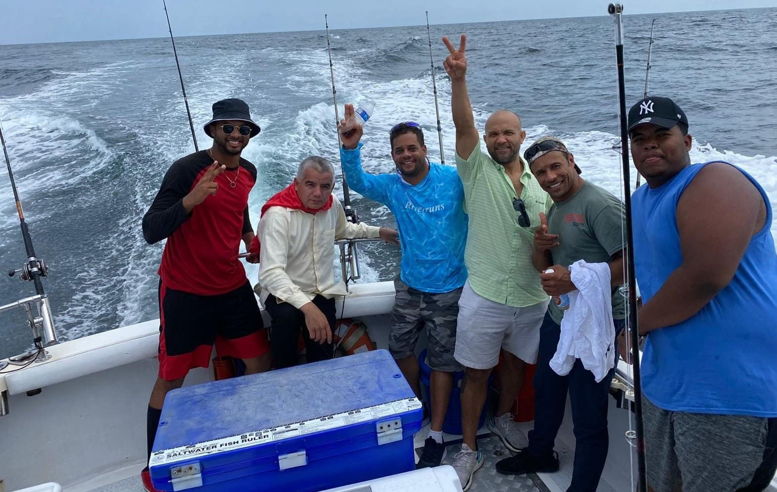 A group of men on a boat holding onto rods