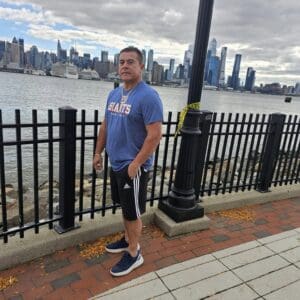 Man wearing a Giants shirt by the water.