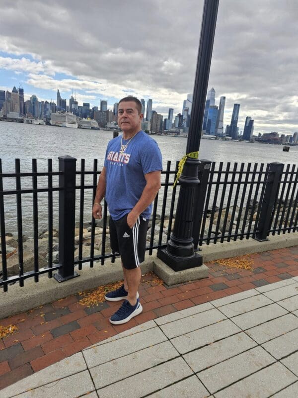 Man wearing a Giants shirt by the water.