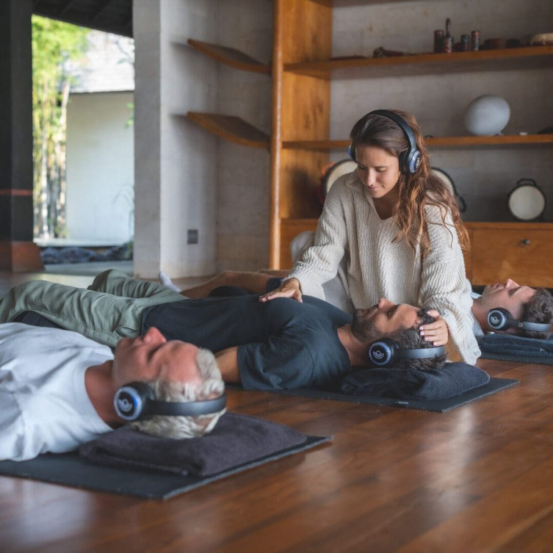 A man and woman laying on the ground listening to music.