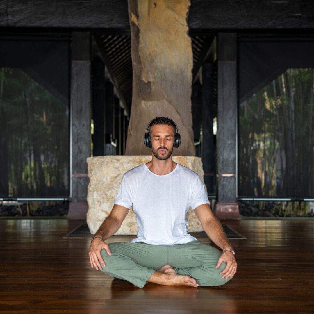 A man sitting in the middle of a yoga pose.